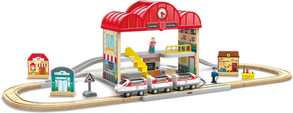 Toy train set with a station building and tracks on a white background