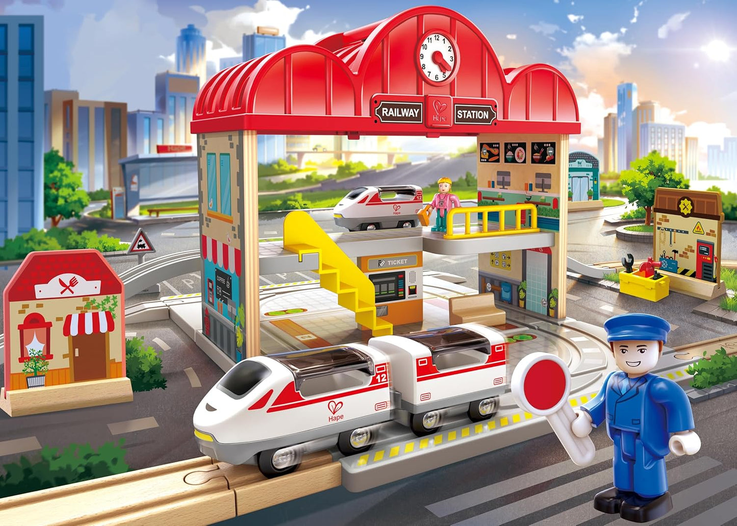 Toy railway station set with train and station staff figure in an urban setting
