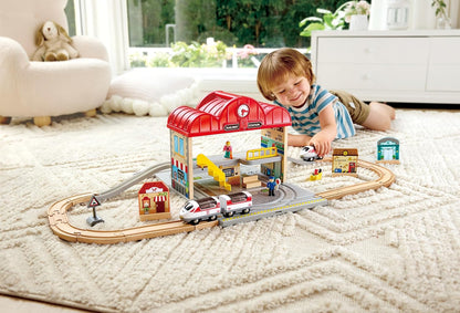 Child playing with a toy train set in a living room